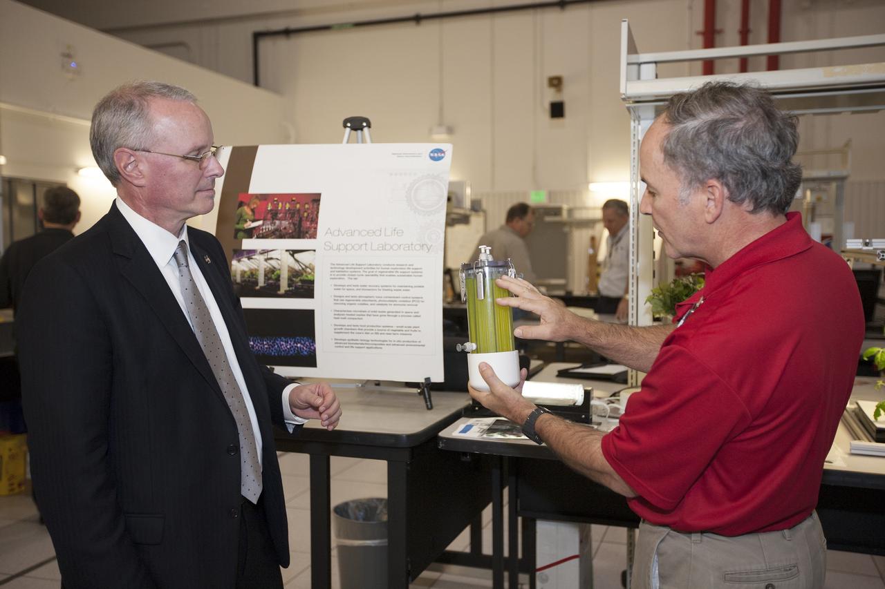 CAPE CANAVERAL, Fla. -- During a visit to NASA's Kennedy Space Center in Florida, NASA Chief Technologist David Miller, left, tours laboratories inside the Swamp Works facility. At right, Dr. Ray Wheeler, a plant physiologist in the Engineering and Technology Directorate discusses a wastewater treatment experiment with Miller. Photo credit: NASA/Kim Shiflett