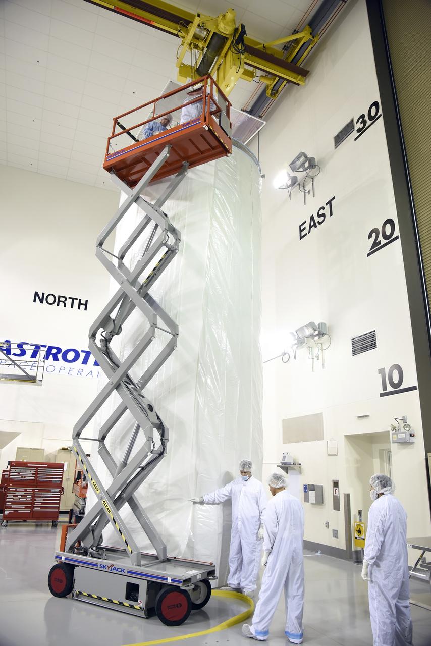 VANDENBERG AIR FORCE BASE, Calif. – In the Astrotech payload processing facility on Vandenberg Air Force Base in California, technicians enclose a transportation canister containing NASA's Soil Moisture Active Passive, or SMAP, spacecraft in an environmentally protective wrap for its move to the launch pad.    SMAP will launch on a United Launch Alliance Delta II 7320 configuration vehicle featuring a United Launch Alliance first stage booster powered by an Aerojet Rocketdyne RS-27A main engine and three Alliant Techsystems, or ATK, strap-on solid rocket motors. Once on station in Earth orbit, SMAP will provide global measurements of soil moisture and its freeze/thaw state. These measurements will be used to enhance understanding of processes that link the water, energy and carbon cycles, and to extend the capabilities of weather and climate prediction models. SMAP data also will be used to quantify net carbon flux in boreal landscapes and to develop improved flood prediction and drought monitoring capabilities. Launch from Space Launch Complex 2 is targeted for Jan. 29. To learn more about SMAP, visit http://www.nasa.gov/smap.  Photo credit: NASA/U.S. Air Force Photo Squadron