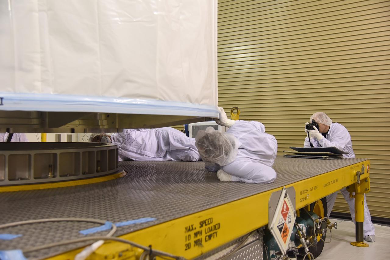 VANDENBERG AIR FORCE BASE, Calif. – In the Astrotech payload processing facility on Vandenberg Air Force Base in California, technicians check the alignment of NASA's Soil Moisture Active Passive, or SMAP, spacecraft, onto a transporter for its move to the launch pad. The spacecraft is being prepared for its move to the launch pad.    SMAP will launch on a United Launch Alliance Delta II 7320 configuration vehicle featuring a United Launch Alliance first stage booster powered by an Aerojet Rocketdyne RS-27A main engine and three Alliant Techsystems, or ATK, strap-on solid rocket motors. Once on station in Earth orbit, SMAP will provide global measurements of soil moisture and its freeze/thaw state. These measurements will be used to enhance understanding of processes that link the water, energy and carbon cycles, and to extend the capabilities of weather and climate prediction models. SMAP data also will be used to quantify net carbon flux in boreal landscapes and to develop improved flood prediction and drought monitoring capabilities. Launch from Space Launch Complex 2 is targeted for Jan. 29. To learn more about SMAP, visit http://www.nasa.gov/smap.  Photo credit: NASA/U.S. Air Force Photo Squadron