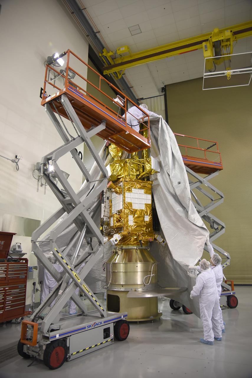 VANDENBERG AIR FORCE BASE, Calif. – Inside the Astrotech payload processing facility at Vandenberg Air Force Base in California, engineers and technicians place a protective cover over NASA's Soil Moisture Active Passive mission, or SMAP, satellite prior the spacecraft being transported to the launch pad.    SMAP will provide global measurements of soil moisture and its freeze/thaw state. These measurements will be used to enhance understanding of processes that link the water, energy and carbon cycles, and to extend the capabilities of weather and climate prediction models. SMAP data also will be used to quantify net carbon flux in boreal landscapes and to develop improved flood prediction and drought monitoring capabilities. Launch is scheduled for Jan. 29, 2015. To learn more about SMAP, visit http://smap.jpl.nasa.gov Photo credit: Jeremy Moore, USAF Photo Squadron