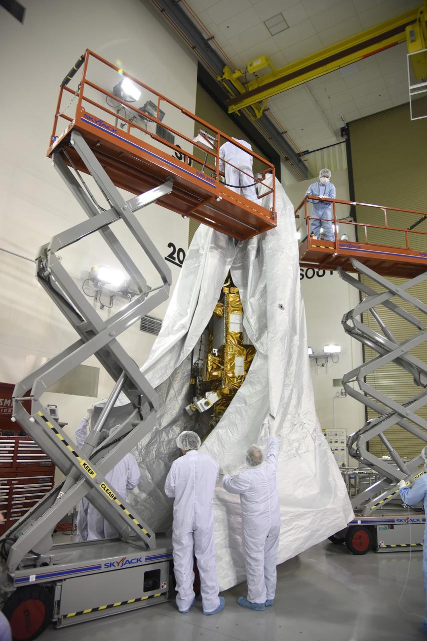 VANDENBERG AIR FORCE BASE, Calif. – Inside the Astrotech payload processing facility at Vandenberg Air Force Base in California, engineers and technicians place a protective cover over NASA's Soil Moisture Active Passive mission, or SMAP, satellite prior the spacecraft being transported to the launch pad. SMAP will provide global measurements of soil moisture and its freeze/thaw state. These measurements will be used to enhance understanding of processes that link the water, energy and carbon cycles, and to extend the capabilities of weather and climate prediction models. SMAP data also will be used to quantify net carbon flux in boreal landscapes and to develop improved flood prediction and drought monitoring capabilities. Launch is scheduled for Jan. 29, 2015. To learn more about SMAP, visit http://smap.jpl.nasa.gov Photo credit: Jeremy Moore, USAF Photo Squadron