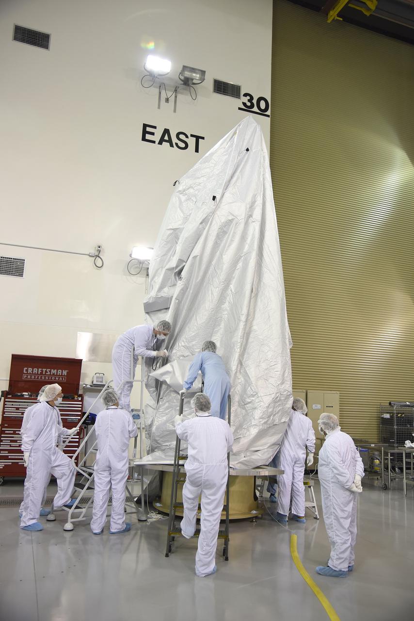 VANDENBERG AIR FORCE BASE, Calif. – Inside the Astrotech payload processing facility at Vandenberg Air Force Base in California, engineers and technicians place a protective cover over NASA's Soil Moisture Active Passive mission, or SMAP, satellite prior the spacecraft being transported to the launch pad.    SMAP will provide global measurements of soil moisture and its freeze/thaw state. These measurements will be used to enhance understanding of processes that link the water, energy and carbon cycles, and to extend the capabilities of weather and climate prediction models. SMAP data also will be used to quantify net carbon flux in boreal landscapes and to develop improved flood prediction and drought monitoring capabilities. Launch is scheduled for Jan. 29, 2015. To learn more about SMAP, visit http://smap.jpl.nasa.gov Photo credit: Jeremy Moore, USAF Photo Squadron