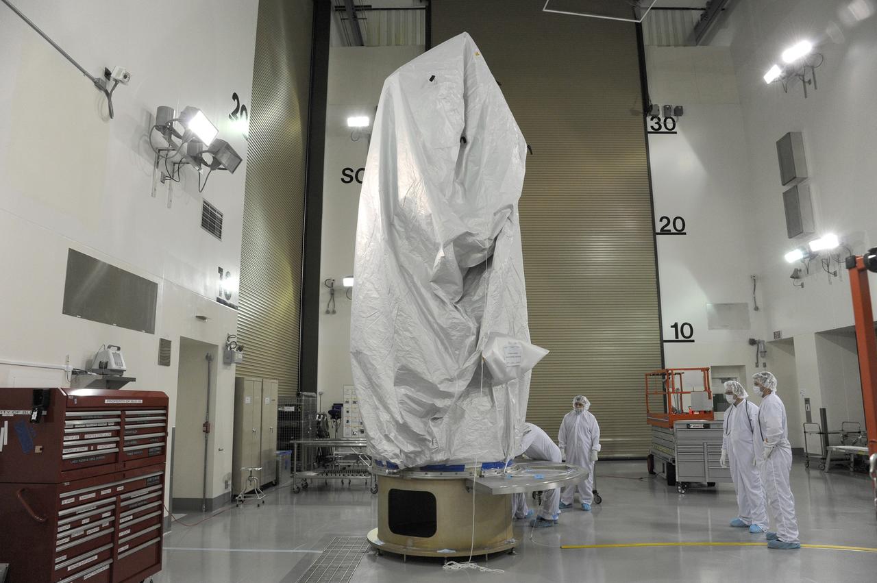 VANDENBERG AFB, California – Technicians and engineers place a transportation canister around NASA's SMAP spacecraft so it can be taken from the Astrotech processing facility to Space Launch Complex-2 for placement atop a Delta II rocket for launch. For more, go to www.nasa.gov/smap Photo credit: USAF/John Davila