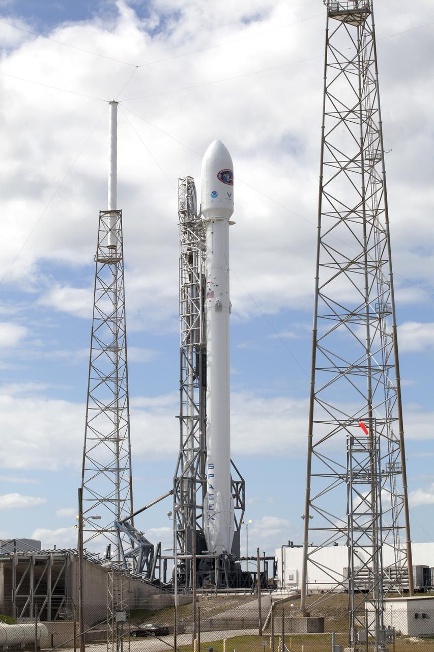 CAPE CANAVERAL, Fla. – CAPE CANAVERAL, Fla. – Backdropped by a blue sky streaked with white clouds, the SpaceX Falcon 9 rocket set to launch NOAA’s Deep Space Climate Observatory spacecraft, or DSCOVR, is flanked by lightning masts at Space Launch Complex 40 at Cape Canaveral Air Force Station in Florida.   DSCOVR is a partnership between NOAA, NASA and the U.S. Air Force. DSCOVR will maintain the nation's real-time solar wind monitoring capabilities which are critical to the accuracy and lead time of NOAA's space weather alerts and forecasts. To learn more about DSCOVR, visit http://www.nesdis.noaa.gov/DSCOVR. Photo credit: NASA/Kim Shiflett