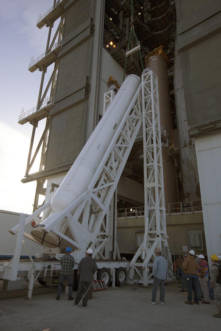 A solid rocket motor for the United Launch Alliance Atlas V rocket slated to boost NASA's Magnetospheric Multiscale mission, or MMS, is lifted at the mobile service tower at Space Launch Complex 41 on Cape Canaveral Air Force Station in Florida. Four identical MMS spacecraft will study the mystery of how magnetic fields around Earth connect and disconnect, explosively releasing energy via a process known a magnetic reconnection. Launch is set for March 12. To learn more: http://www.nasa.gov/mms. Photo credit: NASA/ Kim Shiflett