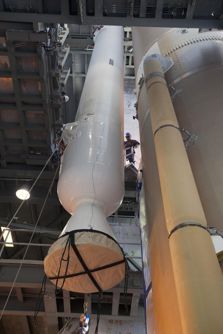 A solid rocket motor for the United Launch Alliance Atlas V rocket slated to boost NASA's Magnetospheric Multiscale mission, or MMS, is lowered into position inside the mobile service tower at Space Launch Complex 41 on Cape Canaveral Air Force Station in Florida. Four identical MMS spacecraft will study the mystery of how magnetic fields around Earth connect and disconnect, explosively releasing energy via a process known a magnetic reconnection. Launch is set for March 12. To learn more: http://www.nasa.gov/mms. Photo credit: NASA/ Kim Shiflett