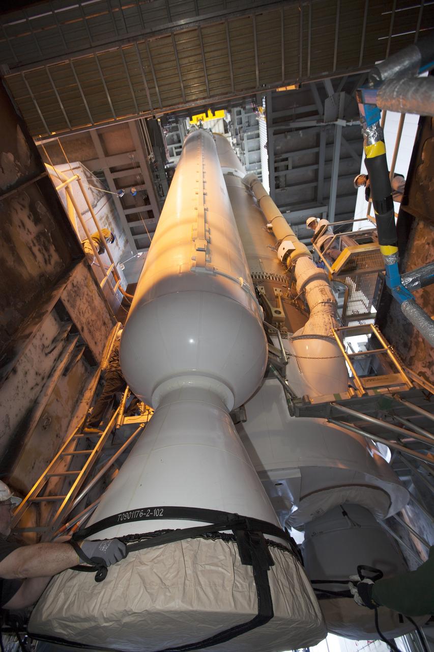 A solid rocket motor for the United Launch Alliance Atlas V rocket slated to boost NASA's Magnetospheric Multiscale mission, or MMS, is lowered into position inside the mobile service tower at Space Launch Complex 41 on Cape Canaveral Air Force Station in Florida. Four identical MMS spacecraft will study the mystery of how magnetic fields around Earth connect and disconnect, explosively releasing energy via a process known a magnetic reconnection. Launch is set for March 12. To learn more: http://www.nasa.gov/mms. Photo credit: NASA/ Kim Shiflett