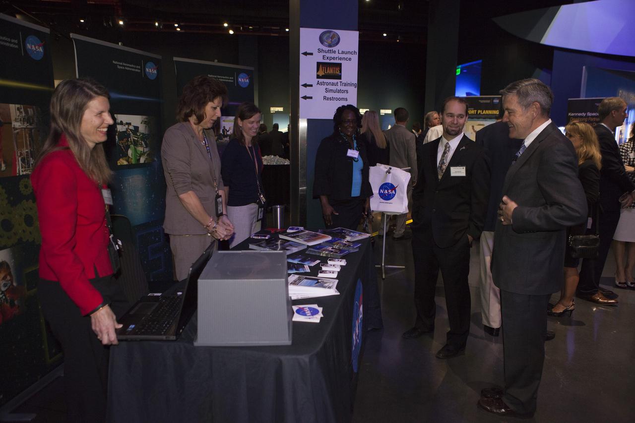 In the Space Shuttle Atlantis exhibit facility at the Kennedy Space Center's Visitor Complex, center director Bob Cabana, right, speaks with guests and employees at the Florida spaceport. This followed a presentation by center director Bob Cabana who updated community leaders on current and future activities at the space center.