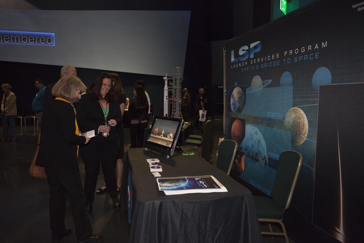 In the Space Shuttle Atlantis exhibit facility at the Kennedy Space Center's Visitor Complex, a guest is briefed on work taking place in the Florida spaceport's Launch Services Program. This followed a presentation by center director Bob Cabana who updated community leaders on current and future activities at the space center.