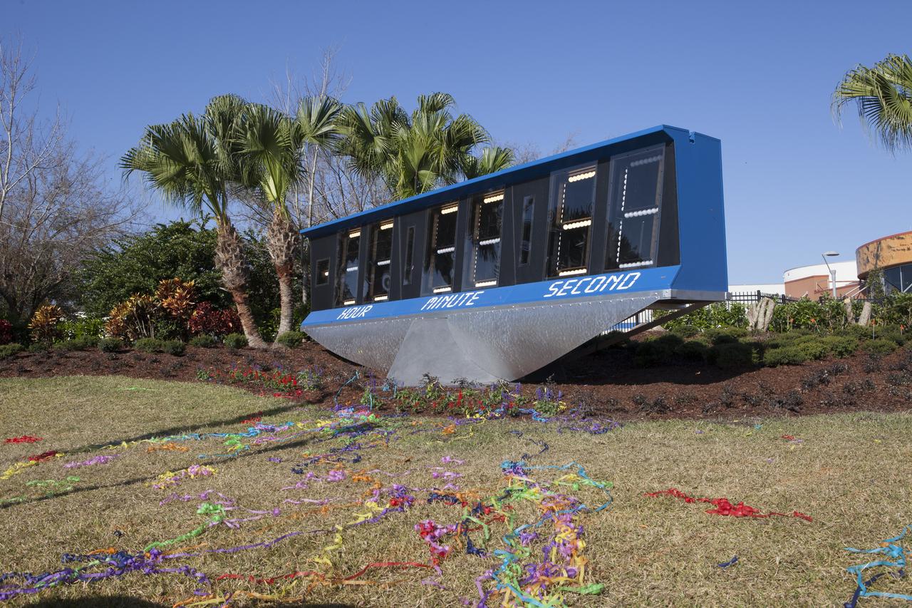 Confetti is launched as the spaceport's historic countdown clock is dedicated as the newest display at the Kennedy Space Center Visitor Complex. Now located at the entrance to the visitor complex, the spaceport's historic countdown clock was used starting with the launch of Apollo 12 on Nov. 14, 1969. Originally set up at the space center's Press Site, the clock operated through the final space shuttle mission, STS-135, launched on July 8, 2011. The old countdown clock was replaced in 2014 with a modern light emitting diode, or LED, display.