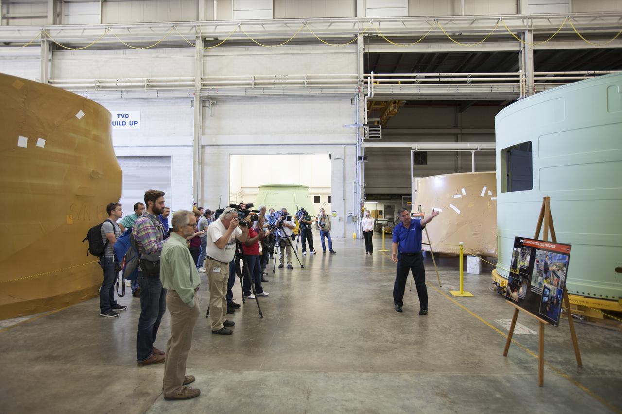 Inside the Booster Fabrication Facility (BFF) at NASA’s Kennedy Space Center in Florida, members of the news media view a forward skirt that will be used on a solid rocket booster for NASA’s Space Launch System (SLS) rocket. Orbital ATK is a contractor for NASA’s Marshall Space Flight Center in Alabama, and operates the BFF to prepare aft booster segments and hardware for the SLS solid rocket boosters. Rick Serfozo, Orbital ATK Florida site director, talks to the media. The SLS rocket and Orion spacecraft will launch on Exploration Mission-1 in 2018. The Ground Systems Development and Operations Program is preparing the infrastructure to process and launch spacecraft for deep-space missions and the journey to Mars. 