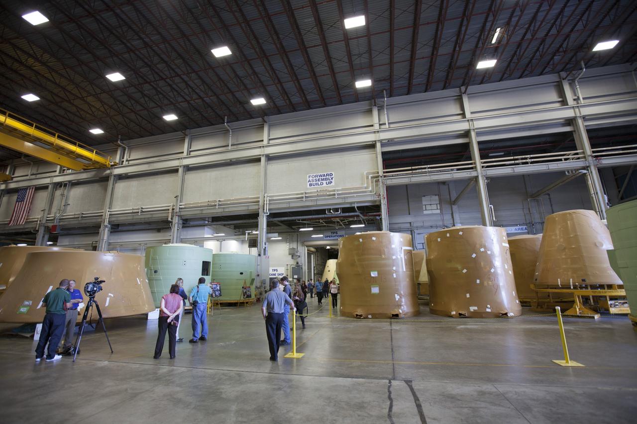 Members of the news media view forward booster segments (painted green) for NASA’s Space Launch System rocket boosters inside the Booster Fabrication Facility (BFF) at NASA’s Kennedy Space Center in Florida. Orbital ATK is a contractor for NASA’s Marshall Space Flight Center in Alabama, and operates the BFF to prepare aft booster segments and hardware for the SLS rocket boosters. The SLS rocket and Orion spacecraft will launch on Exploration Mission-1 in 2018. The Ground Systems Development and Operations Program is preparing the infrastructure to process and launch spacecraft for deep-space missions and the journey to Mars.