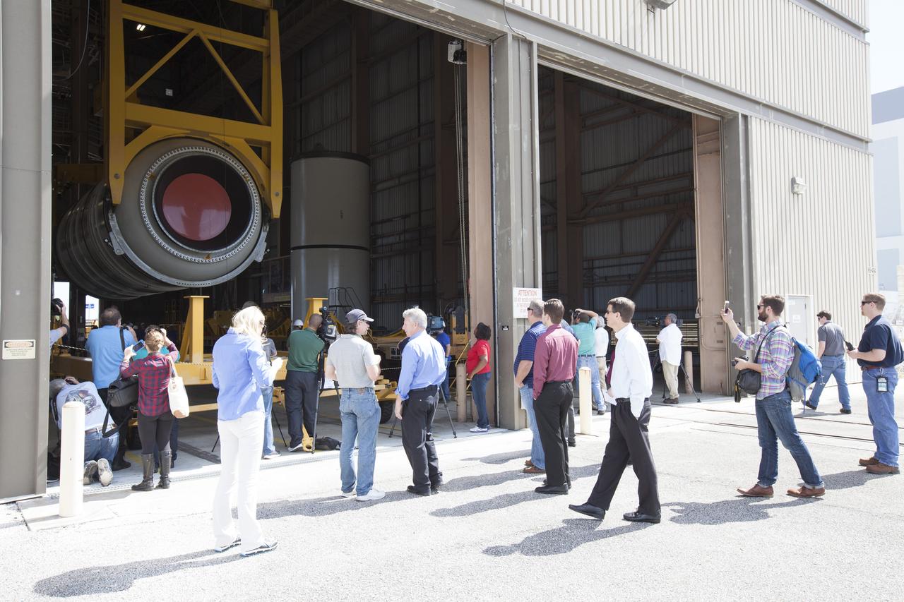 At the Rotation, Processing and Surge Facility (RPSF) at NASA’s Kennedy Space Center in Florida, members of the news media watch as cranes are used to lift one of two pathfinders, or test versions, of solid rocket booster segments for NASA’s Space Launch System rocket. The Ground Systems Development and Operations Program and Jacobs Engineering, on the Test and Operations Support Contract, are preparing the booster segments, which are inert, for a series of lifts, moves and stacking operations to prepare for Exploration Mission-1, deep-space missions and the journey to Mars.