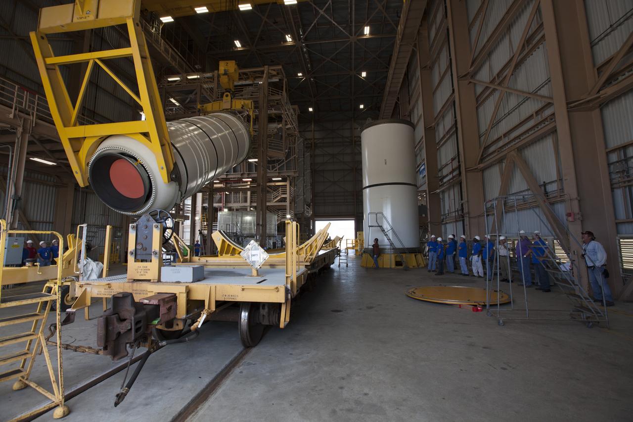 During a media tour of the Rotation, Processing and Surge Facility (RPSF) at NASA’s Kennedy Space Center in Florida, two cranes are used to lift one of two pathfinders, or test versions, of solid rocket booster segments for NASA’s Space Launch System rocket. At far right, the first pathfinder booster has been lifted into the vertical position and secured on a test stand. The Ground Systems Development and Operations Program and Jacobs Engineering, on the Test and Operations Support Contract, will prepare the booster segments, which are inert, for a series of lifts, moves and stacking operations to prepare for Exploration Mission-1, deep-space missions and the journey to Mars.