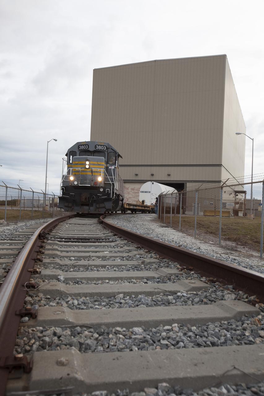 An Iowa Northern locomotive, contracted by Goodloe Transportation of Chicago, departs from the Rotation, Processing and Surge Facility (RPSF) at NASA’s Kennedy Space Center in Florida, with two containers on railcars for transport to the NASA Jay Jay railroad yard. The containers held two pathfinders, or test versions, of solid rocket booster segments for NASA’s Space Launch System rocket that were delivered to the RPSF. Inside the RPSF, the Ground Systems Development and Operations Program and Jacobs Engineering, on the Test and Operations Support Contract, will conduct a series of lifts, moves and stacking operations using the booster segments, which are inert, to prepare for Exploration Mission-1, deep-space missions and the journey to Mars. The pathfinder booster segments are from Orbital ATK in Utah.