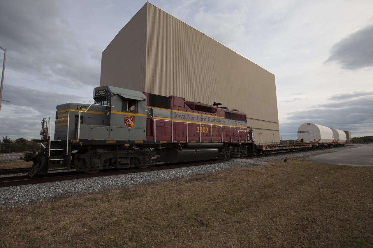 An Iowa Northern locomotive, contracted by Goodloe Transportation of Chicago, departs from the Rotation, Processing and Surge Facility (RPSF) at NASA’s Kennedy Space Center in Florida, with two containers on railcars for transport to the NASA Jay Jay railroad yard. The containers held two pathfinders, or test versions, of solid rocket booster segments for NASA’s Space Launch System rocket that were delivered to the RPSF. Inside the RPSF, the Ground Systems Development and Operations Program and Jacobs Engineering, on the Test and Operations Support Contract, will conduct a series of lifts, moves and stacking operations using the booster segments, which are inert, to prepare for Exploration Mission-1, deep-space missions and the journey to Mars. The pathfinder booster segments are from Orbital ATK in Utah. 