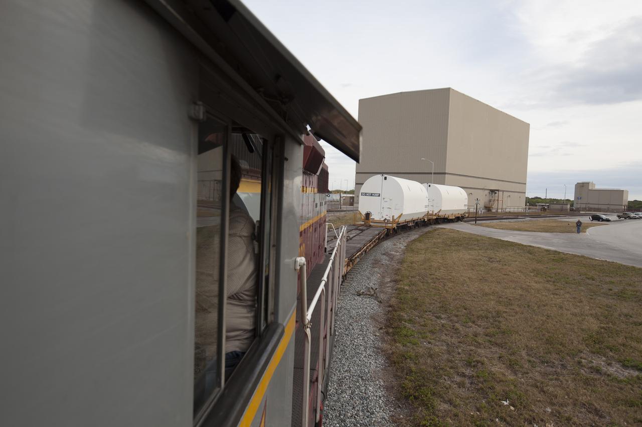 An Iowa Northern locomotive, contracted by Goodloe Transportation of Chicago, departs from the Rotation, Processing and Surge Facility (RPSF) at NASA’s Kennedy Space Center in Florida, with two containers on railcars for transport to the NASA Jay Jay railroad yard. The containers held two pathfinders, or test versions, of solid rocket booster segments for NASA’s Space Launch System rocket that were delivered to the RPSF. Inside the RPSF, the Ground Systems Development and Operations Program and Jacobs Engineering, on the Test and Operations Support Contract, will conduct a series of lifts, moves and stacking operations using the booster segments, which are inert, to prepare for Exploration Mission-1, deep-space missions and the journey to Mars. The pathfinder booster segments are from Orbital ATK in Utah. 
