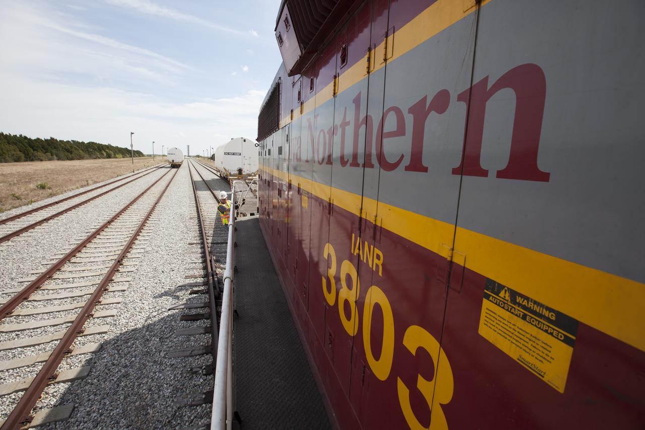 An Iowa Northern locomotive, contracted by Goodloe Transportation of Chicago, arrives at the NASA Jay Jay railroad yard from Kennedy Space Center in Florida, with the second of two containers on a railcar. The first container is at left. The containers held two pathfinders, or test versions, of solid rocket booster segments for NASA’s Space Launch System rocket that were delivered to the Rotation, Processing and Surge Facility (RPSF). Inside the RPSF, the Ground Systems Development and Operations Program and Jacobs Engineering, on the Test and Operations Support Contract, will conduct a series of lifts, moves and stacking operations using the booster segments, which are inert, to prepare for Exploration Mission-1, deep-space missions and the journey to Mars. The pathfinder booster segments are from Orbital ATK in Utah.