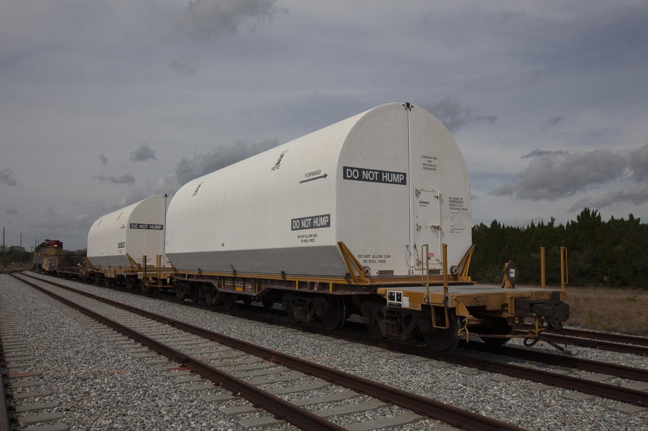 An Iowa Northern locomotive, contracted by Goodloe Transportation of Chicago, arrives at the NASA Jay Jay railroad yard from Kennedy Space Center in Florida, with two containers on railcars for storage. The containers held two pathfinders, or test versions, of solid rocket booster segments for NASA’s Space Launch System rocket that were delivered to the Rotation, Processing and Surge Facility (RPSF). Inside the RPSF, the Ground Systems Development and Operations Program and Jacobs Engineering, on the Test and Operations Support Contract, will conduct a series of lifts, moves and stacking operations using the booster segments, which are inert, to prepare for Exploration Mission-1, deep-space missions and the journey to Mars. The pathfinder booster segments are from Orbital ATK in Utah.