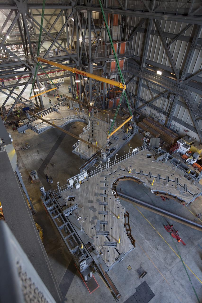 Preparations are underway to lift the second half of the K-level work platforms for NASA’s Space Launch System (SLS) rocket up from High Bay 4 inside the Vehicle Assembly Building at NASA's Kennedy Space Center in Florida. The platform will be lifted up and over the transfer aisle and then lowered into High Bay 3 for installation. It will be secured about 86 feet above the VAB floor, on tower E of the high bay. The K work platforms will provide access to the SLS core stage and solid rocket boosters during processing and stacking operations on the mobile launcher. The Ground Systems Development and Operations Program is overseeing upgrades and modifications to High Bay 3 to support processing of the SLS and Orion spacecraft. A total of 10 levels of new platforms, 20 platform halves altogether, will surround the SLS rocket and Orion spacecraft.