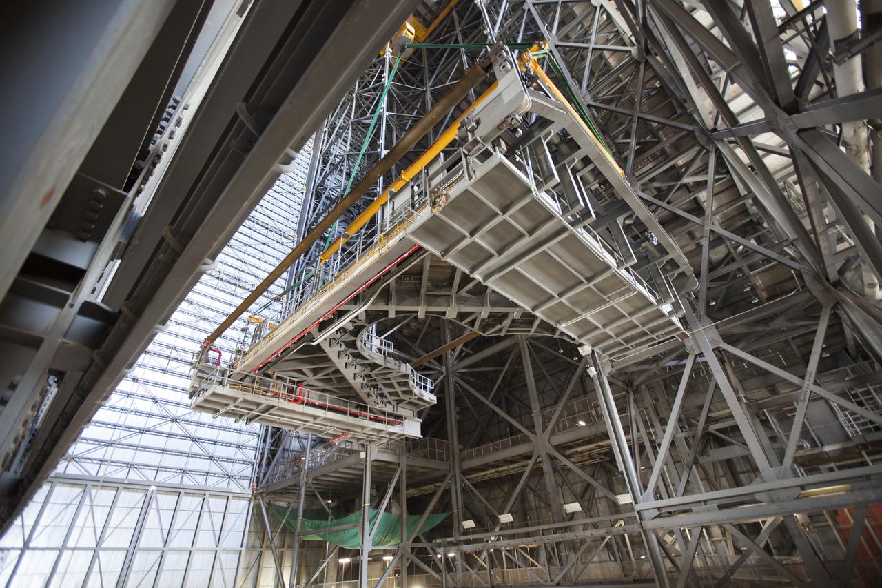A 250-ton crane is used to lift the second half of the K-level work platforms for NASA’s Space Launch System (SLS) rocket up from High Bay 4 inside the Vehicle Assembly Building at NASA's Kennedy Space Center in Florida. The platform will be lifted up and over the transfer aisle and then lowered into High Bay 3 for installation. It will be secured about 86 feet above the VAB floor, on tower E of the high bay. The K work platforms will provide access to the SLS core stage and solid rocket boosters during processing and stacking operations on the mobile launcher. The Ground Systems Development and Operations Program is overseeing upgrades and modifications to High Bay 3 to support processing of the SLS and Orion spacecraft. A total of 10 levels of new platforms, 20 platform halves altogether, will surround the SLS rocket and Orion spacecraft.