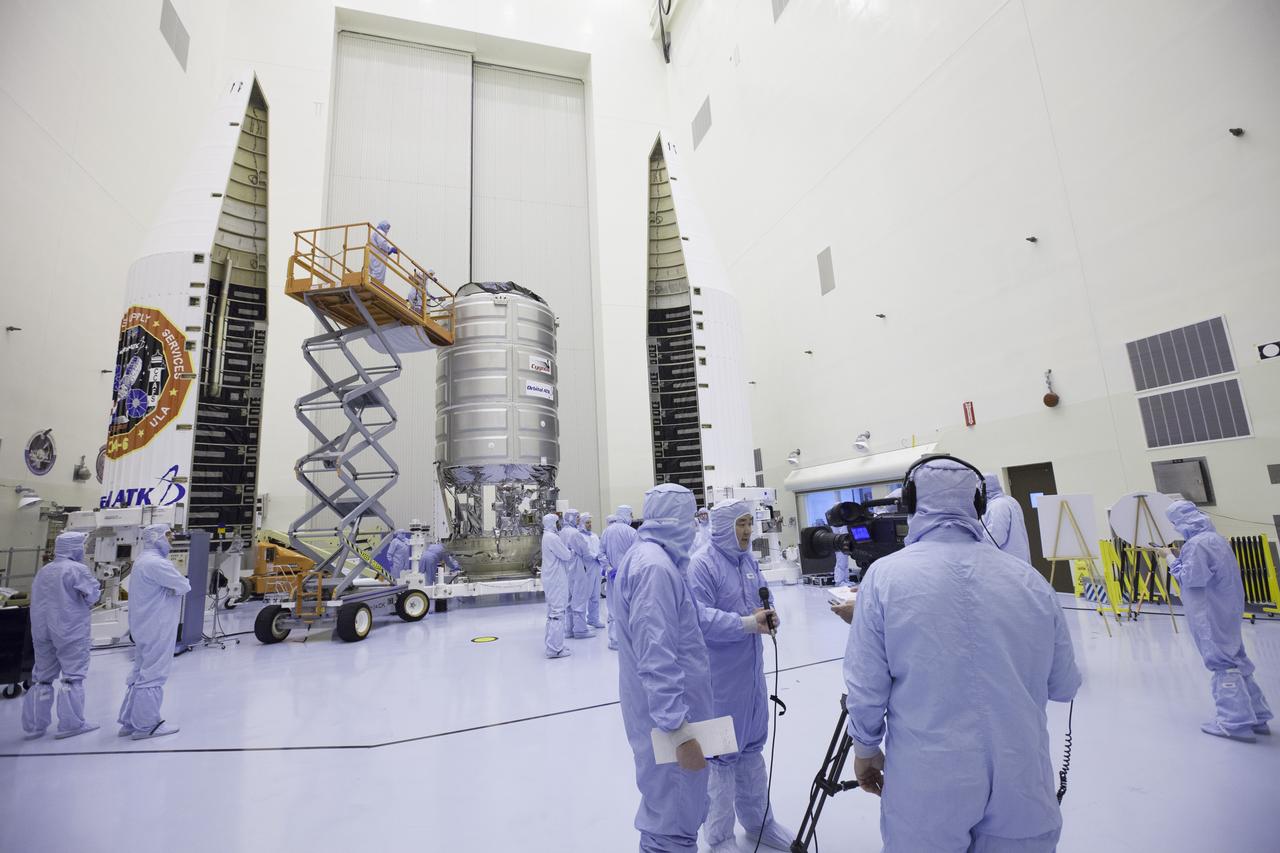 Inside the Payload Hazardous Servicing Facility at NASA's Kennedy Space Center, former NASA astronaut Dan Tani, who now is senior director of Missions and Cargo Operations for Orbital ATK in Dulles, Virginia, participates in a press interview. In the background is the Cygnus spacecraft scheduled to deliver hardware and supplies to the International Space Station on the upcoming Orbital ATK Commercial Resupply Services-6 mission.