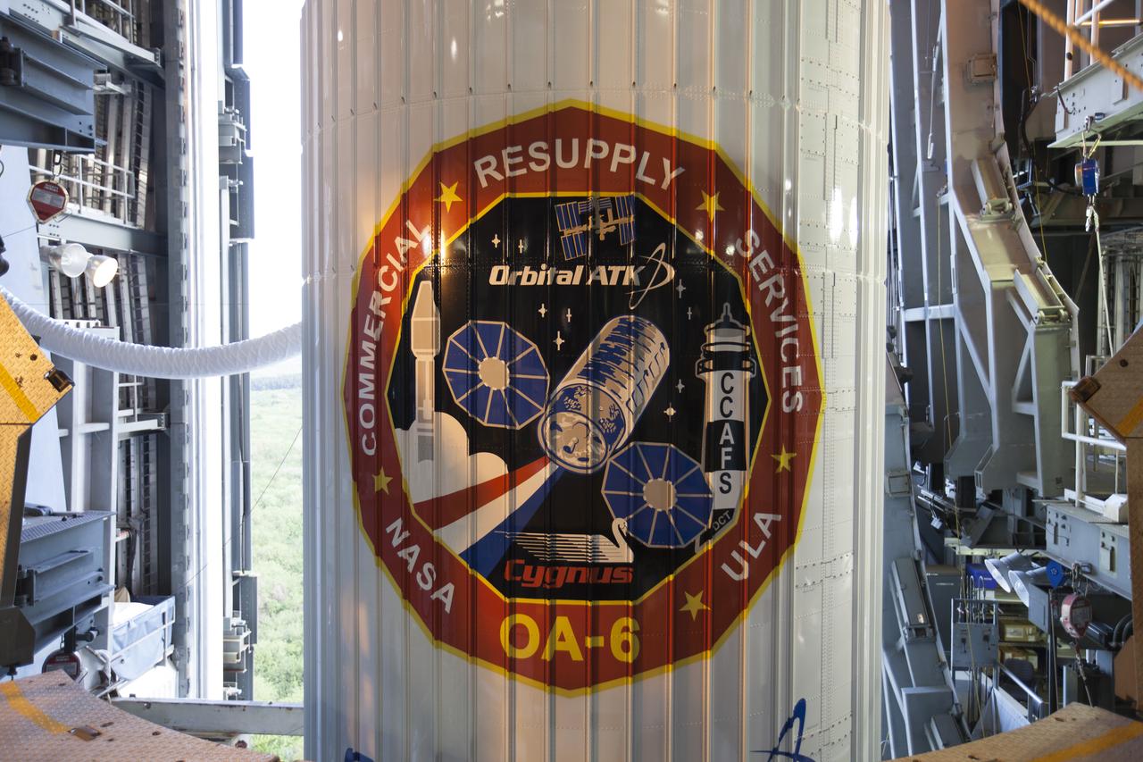 The mission logo for the Orbital ATK CRS-6 mission is visible on the payload fairing encapsulating a Cygnus spacecraft as it is prepared for its move from the Vertical Integration Facility at Cape Canaveral Air Force Station's Space Launch Complex 41. Mounted atop a United Launch Alliance Atlas V rocket, the vehicle will be moved to the launch pad. The Cygnus spacecraft will boost a resupply mission delving science payloads to the International Space Station.