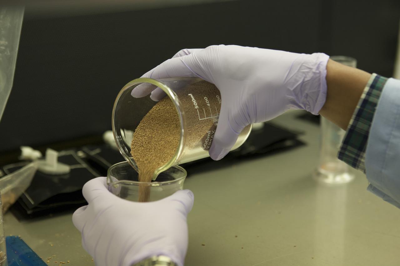 Inside a laboratory in the Space Station Processing Facility at NASA’s Kennedy Space Center in Florida, research scientists prepare the plant pillows for the Veg-03 experiment that will be delivered to the International Space Station aboard the eighth SpaceX Dragon commercial resupply mission. Matt Romeyn, a NASA pathways intern, measures out the calcined clay, or space dirt, for one of the plant pillows. The Veg-03 plant pillows will contain ‘Tokyo Bekana’ cabbage seeds and lettuce seeds for NASA’s third Veggie plant growth system experiment. The experiment will continue NASA’s deep space plant growth research to benefit the Earth and the agency’s journey to Mars. 