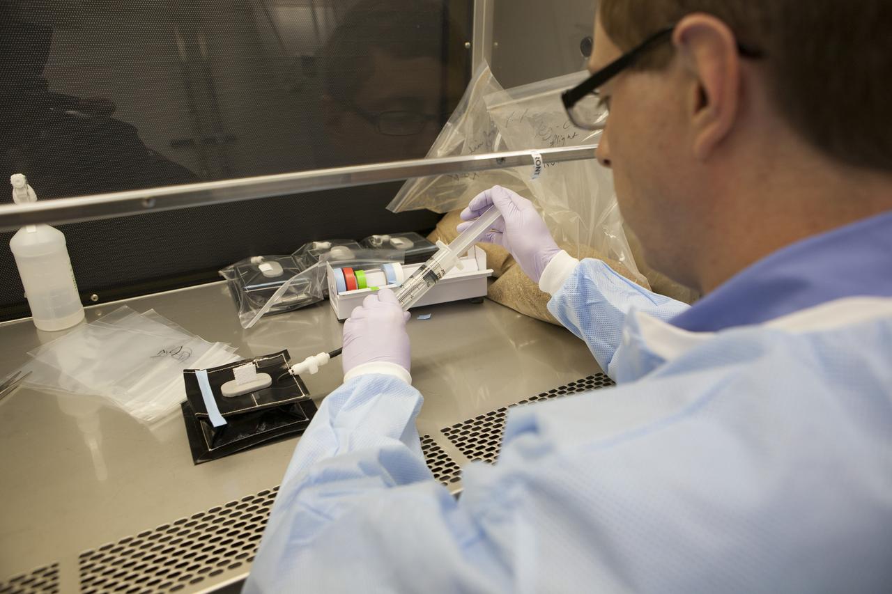 Inside a laboratory in the Space Station Processing Facility at NASA’s Kennedy Space Center in Florida, research scientists prepare the plant pillows for the Veg-03 experiment that will be delivered to the International Space Station aboard the eighth SpaceX Dragon commercial resupply mission. Dr. Mathew Mickens, a post-doctoral researcher, inserts a bonding agent into one of the Veg-03 plant pillows. The Veg-03 plant pillows will contain ‘Tokyo Bekana’ cabbage seeds and lettuce seeds for NASA’s third Veggie plant growth system experiment. The experiment will continue NASA’s deep space plant growth research to benefit the Earth and the agency’s journey to Mars. 