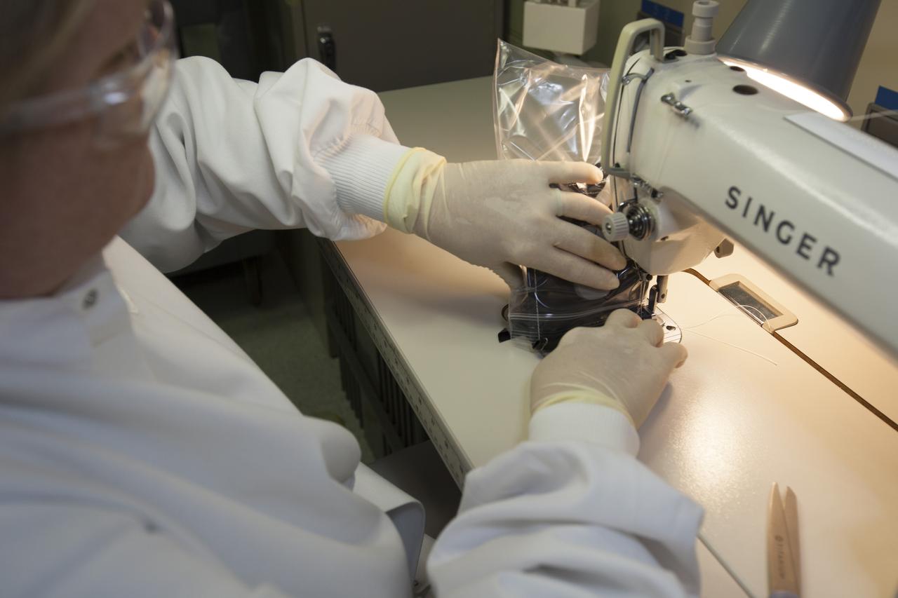 Inside a laboratory in the Space Station Processing Facility at NASA’s Kennedy Space Center in Florida, Michele Koralewicz, a mechanical technician with EASI on the Engineering Services Contract, sews up the end of a bag that contains one of the Veg-03 plant pillows. The Veg-03 experiment will be delivered to the International Space Station aboard the eighth SpaceX Dragon commercial resupply mission. The Veg-03 plant pillows will contain ‘Tokyo Bekana’ cabbage seeds and lettuce seeds for NASA’s third Veggie plant growth system experiment. The experiment will continue NASA’s deep space plant growth research to benefit the Earth and the agency’s journey to Mars. 