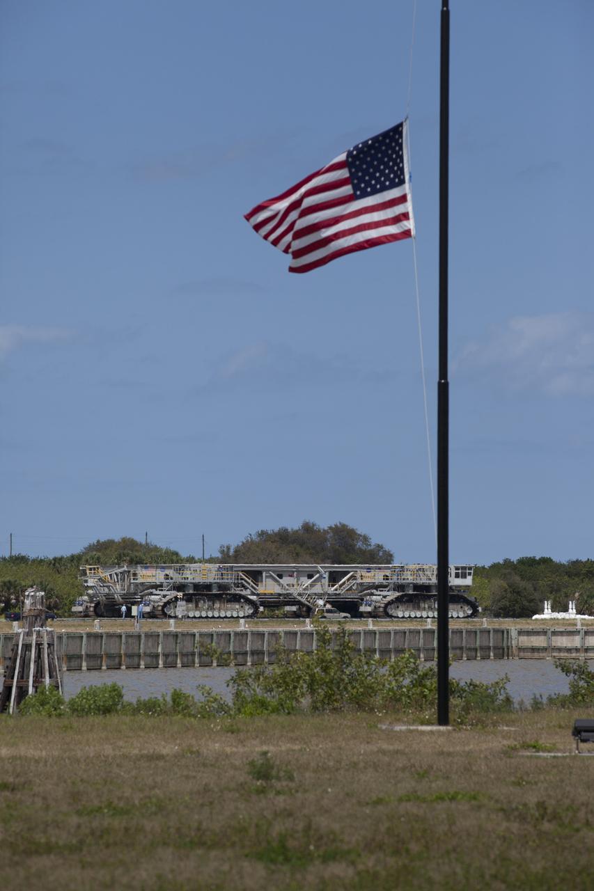 An American flag flutters in the breeze as NASA’s upgraded crawler-transporter 2 (CT-2) travels along the crawlerway during its trek to Launch Pad 39B at the agency’s Kennedy Space Center in Florida, to test recently completed upgrades and modifications for NASA’s journey to Mars. The Ground Systems Development and Operations Program at Kennedy oversaw upgrades to the crawler in the Vehicle Assembly Building. The crawler will carry the mobile launcher with Orion atop the Space Launch System rocket to Pad 39B for Exploration Mission-1, scheduled for 2018.