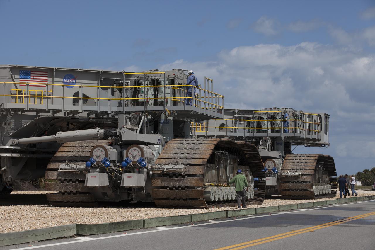 Technicians walk alongside NASA’s upgraded crawler-transporter 2 (CT-2) as it continues the trek on the crawlerway from the Vehicle Assembly Building (VAB) at the agency’s Kennedy Space Center in Florida to Launch Pad 39B to test recently completed upgrades and modifications for NASA’s journey to Mars. The Ground Systems Development and Operations Program at Kennedy oversaw upgrades to the crawler in the VAB. The crawler will carry the mobile launcher with Orion atop the Space Launch System rocket to Pad 39B for Exploration Mission-1, scheduled for 2018.