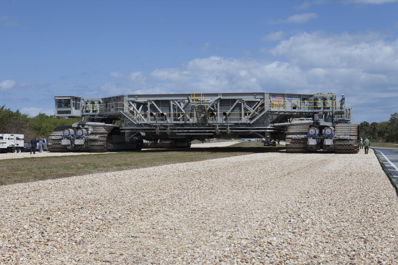 Technicians walk alongside NASA’s upgraded crawler-transporter 2 (CT-2) as it continues the trek on the crawlerway from the Vehicle Assembly Building (VAB) at the agency’s Kennedy Space Center in Florida to Launch Pad 39B to test recently completed upgrades and modifications for NASA’s journey to Mars. The Ground Systems Development and Operations Program at Kennedy oversaw upgrades to the crawler in the VAB. The crawler will carry the mobile launcher with Orion atop the Space Launch System rocket to Pad 39B for Exploration Mission-1, scheduled for 2018. 