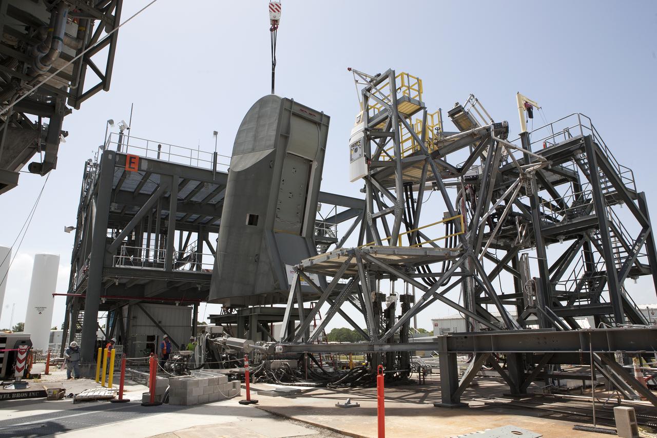 Technician monitors the progress as a crane lowers the first Tail Service Mast Umbilical (TSMU) onto a test stand at the Launch Equipment Test Facility at NASA’s Kennedy Space Center in Florida. Two TSMUs will provide liquid propellants and power to the Space Launch System (SLS) rocket’s core stage engine. Both TSMUs will connect to the zero-level deck on the mobile launcher, providing fuel and electricity to the SLS rocket before it launches on Exploration Mission 1. The TSMU will undergo testing and validation at the LETF to verify it is functioning properly. The center’s Engineering Directorate and the Ground Systems Development and Operations Program are overseeing processing and testing of the umbilicals. 