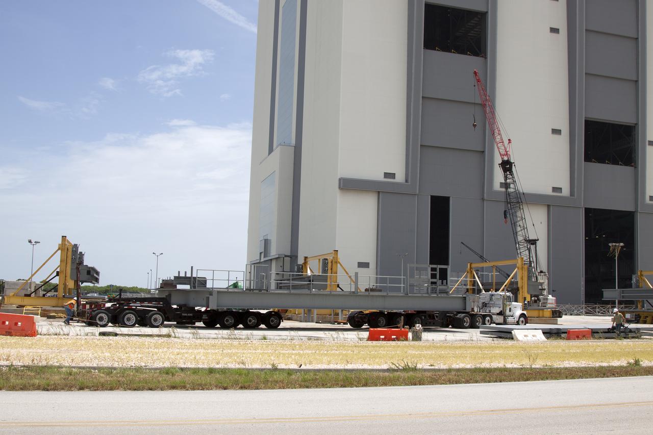 A heavy load transport truck from Tillett Heavy Hauling in Titusville, Florida, arrives at the Vehicle Assembly Building (VAB) at NASA’s Kennedy Space Center in Florida, carrying a section of the first half of the C-level work platforms, C south, for the agency’s Space Launch System (SLS) rocket. The platform will be delivered to the VAB staging area in the west parking lot. The Ground Systems Development and Operations Program is overseeing upgrades and modifications to VAB High Bay 3 to support processing of the SLS and Orion spacecraft. A total of 10 levels of new platforms, 20 platform halves altogether, will surround the SLS rocket and Orion spacecraft and provide access for testing and processing.