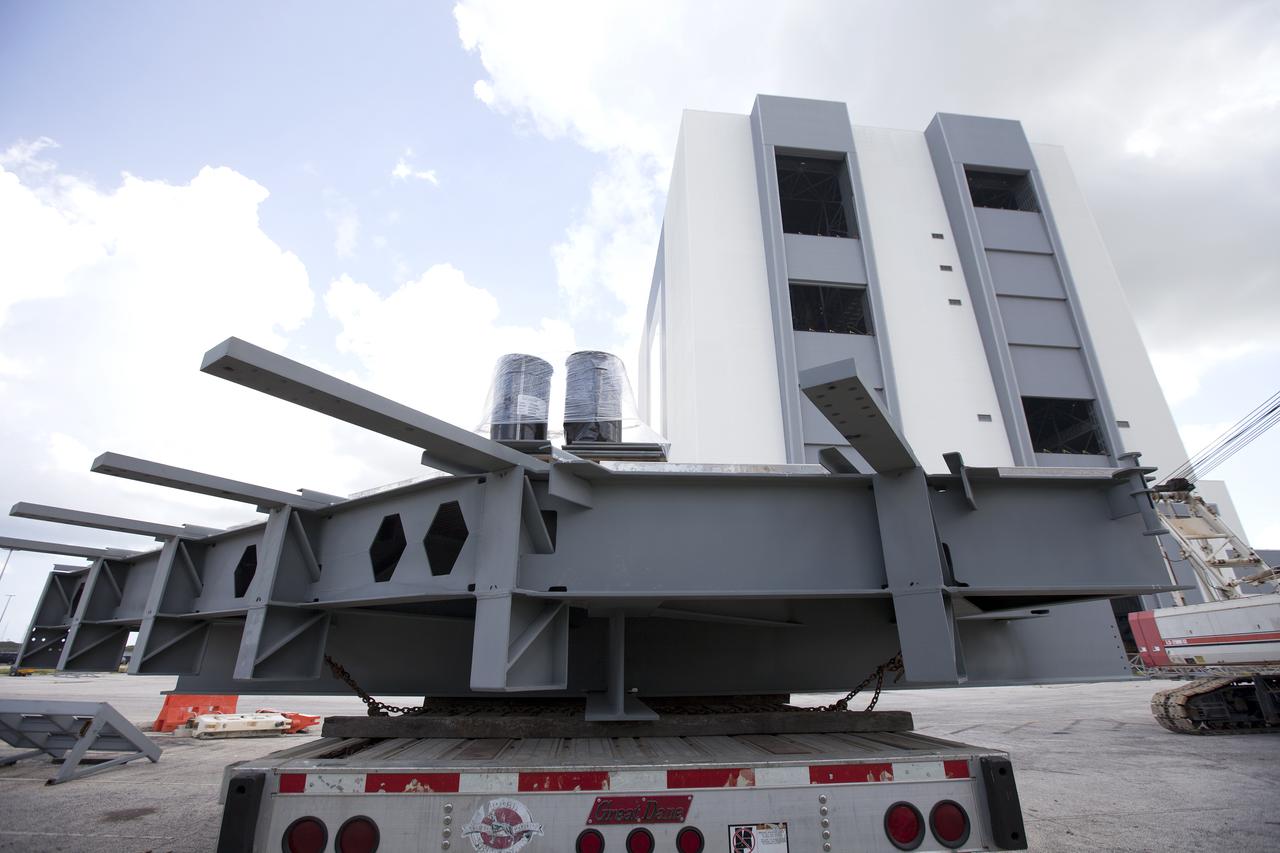 A heavy load transport truck from Tillett Heavy Hauling in Titusville, Florida, arrives at the Vehicle Assembly Building (VAB) at NASA’s Kennedy Space Center in Florida, carrying the second section of the first half of the C-level work platforms, C South, for the agency’s Space Launch System (SLS) rocket. The platform will be offloaded in the VAB staging area in the west parking lot. The Ground Systems Development and Operations Program is overseeing upgrades and modifications to VAB High Bay 3 to support processing of the SLS and Orion spacecraft. A total of 10 levels of new platforms, 20 platform halves altogether, will surround the SLS rocket and Orion spacecraft and provide access for testing and processing. 