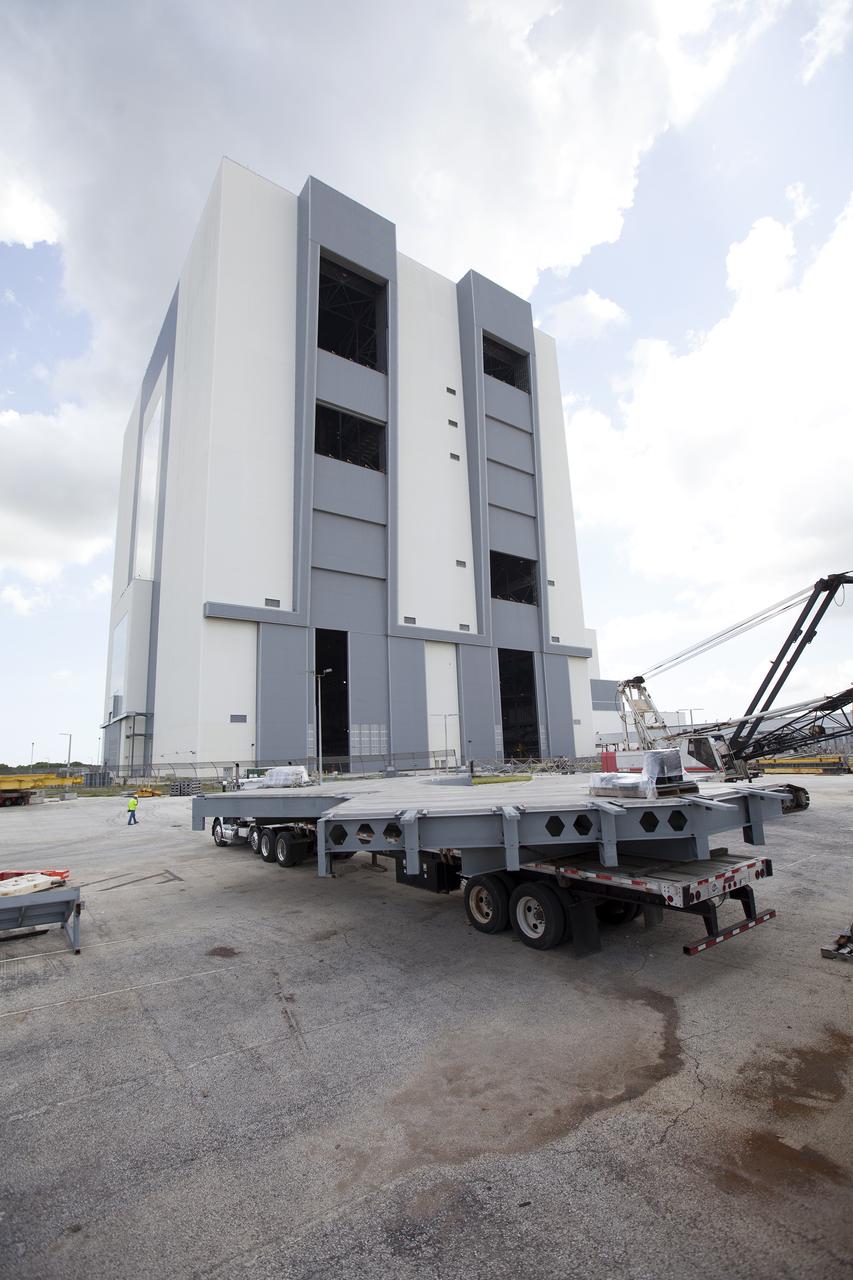 A heavy load transport truck from Tillett Heavy Hauling in Titusville, Florida, arrives at the Vehicle Assembly Building (VAB) at NASA’s Kennedy Space Center in Florida, carrying the second section of the first half of the C-level work platforms, C South, for the agency’s Space Launch System (SLS) rocket. The platform will be offloaded in the VAB staging area in the west parking lot. The Ground Systems Development and Operations Program is overseeing upgrades and modifications to VAB High Bay 3 to support processing of the SLS and Orion spacecraft. A total of 10 levels of new platforms, 20 platform halves altogether, will surround the SLS rocket and Orion spacecraft and provide access for testing and processing. 