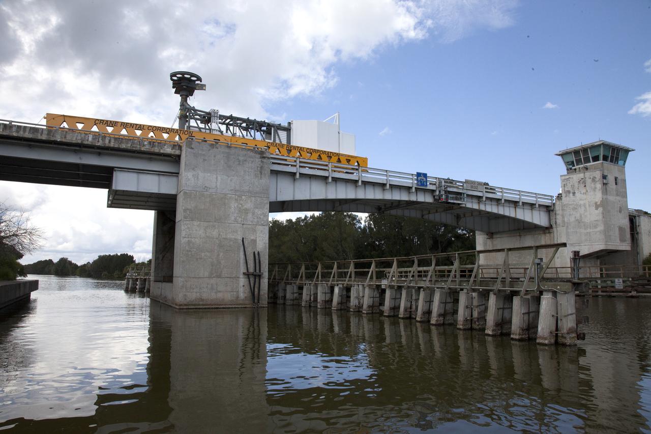 A heavy-lift transport truck, carrying the Crew Access Arm for Space Launch Complex 41, crosses the Haulover Canal Bridge on its way to the entrance of NASA’s Kennedy Space Center in Florida. The arm will be installed on the Complex 41 Crew Access Tower at Cape Canaveral Air Force Station. It will be used as a bridge by astronauts to board Boeing's CST-100 Starliner spacecraft as it stands on the launch pad atop a United Launch Alliance Atlas V rocket.