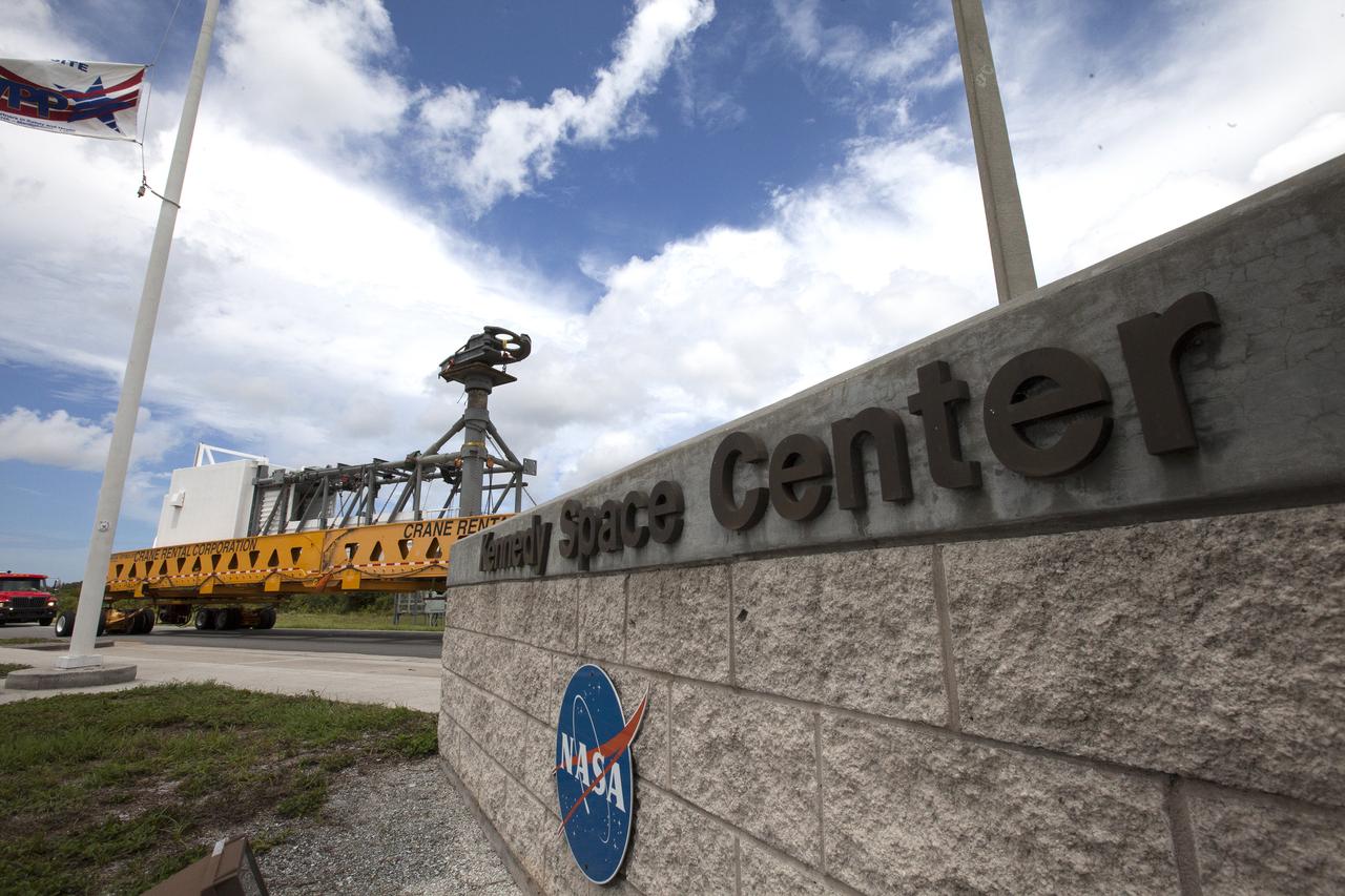 A heavy-lift transport truck, carrying the Crew Access Arm for Space Launch Complex 41, passes through the entrance to NASA’s Kennedy Space Center in Florida. The arm will be installed on the Complex 41 Crew Access Tower at Cape Canaveral Air Force Station. It will be used as a bridge by astronauts to board Boeing's CST-100 Starliner spacecraft as it stands on the launch pad atop a United Launch Alliance Atlas V rocket.
