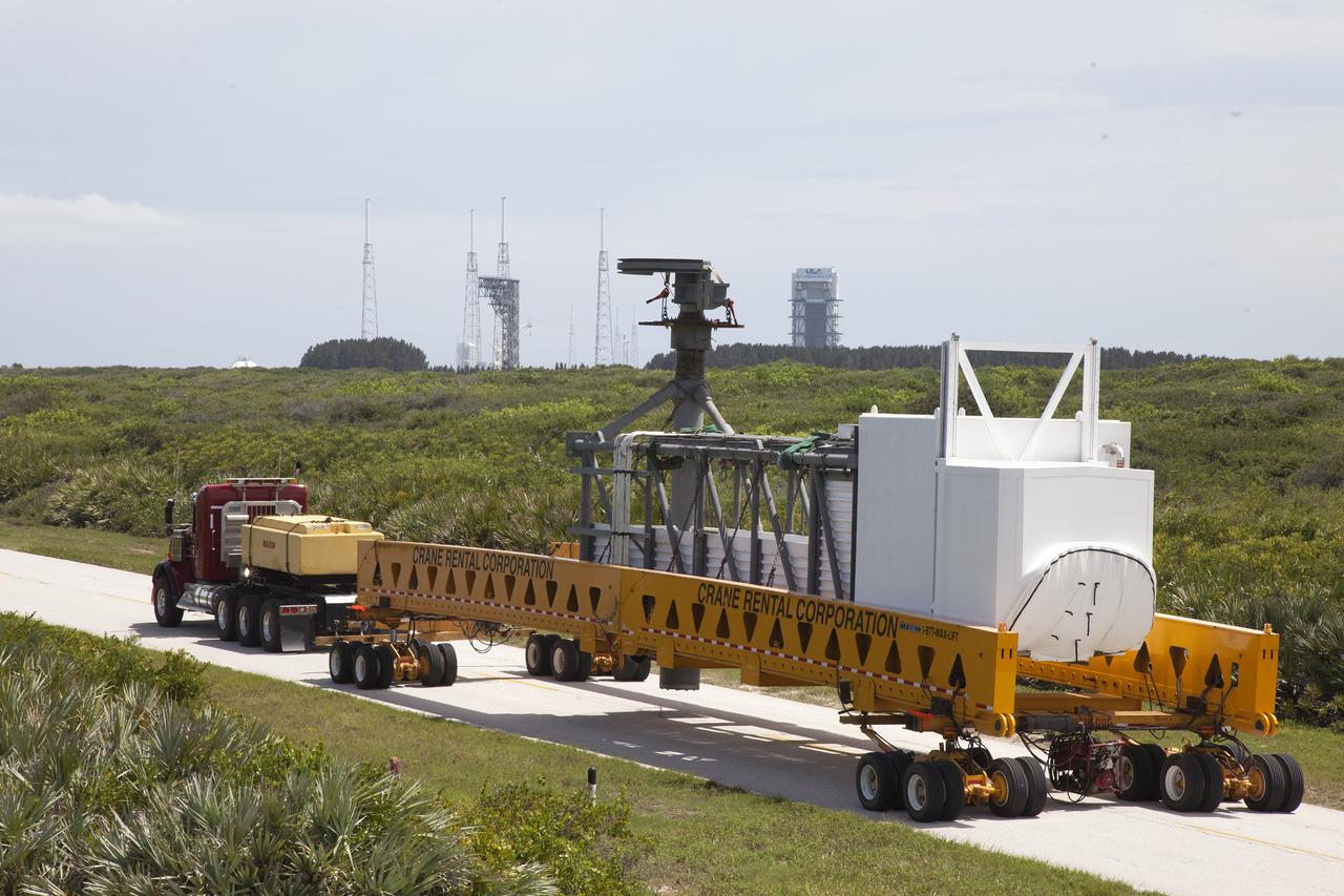 A heavy-lift transport truck, carrying the Crew Access Arm for Space Launch Complex 41, travels along the road toward Complex 41 at Cape Canaveral Air Force Station in Florida. The arm will be installed on the Complex 41 Crew Access Tower. It will be used as a bridge by astronauts to board Boeing's CST-100 Starliner spacecraft as it stands on the launch pad atop a United Launch Alliance Atlas V rocket.