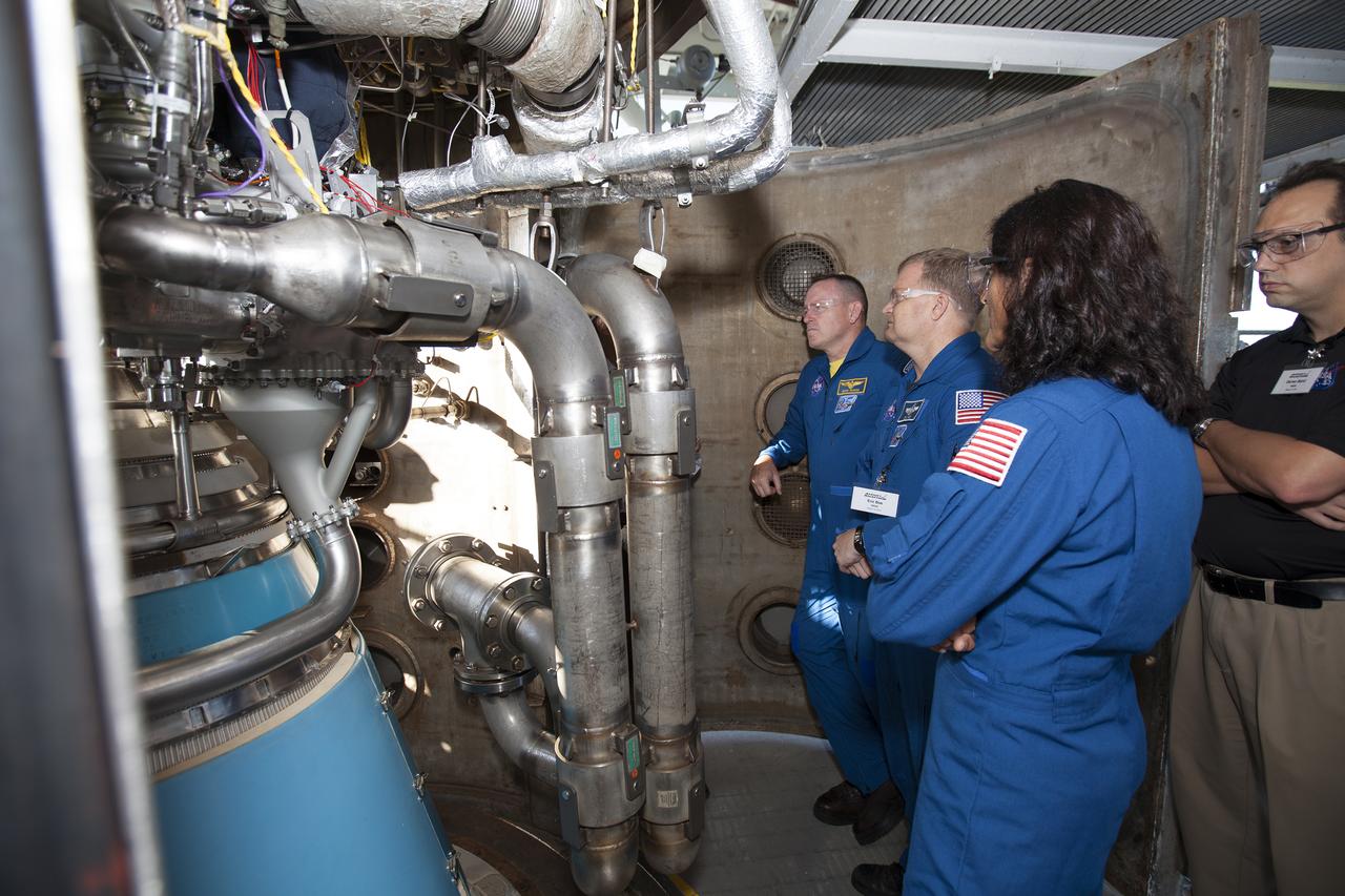 NASA astronauts Barry "Butch" Wilmore, from left, Eric Boe and Suni Williams survey an RL10 engine as it stands in a vacuum chamber at Aerojet Rocketdyne's test stand in West Palm Beach, Florida. The engine will be one of two used for the Centaur upper stage during a United Launch Alliance Atlas V mission to launch Boeing's CST-100 Starliner on a flight test carrying a crew. The engine was test-fired as part of acceptance testing to confirm the engine is ready for flight.
