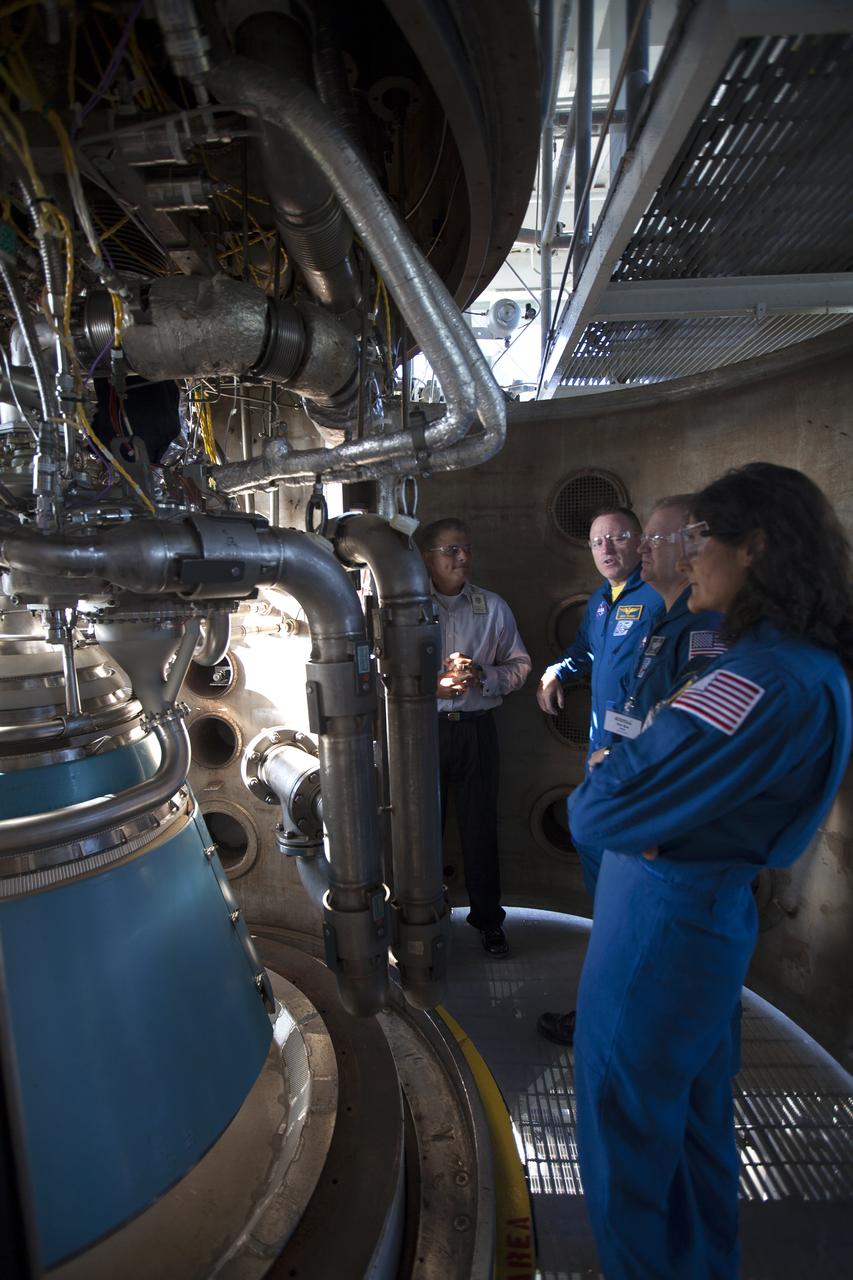 Carlos Rodriguez, from left, manager of systems development, verification and testing for Aerojet Rocketdyne, talks with NASA astronauts Barry "Butch" Wilmore, Eric Boe and Suni Williams as the group surveys an RL10 engine as it stands in a vacuum chamber at Aerojet Rocketdyne's test stand in West Palm Beach, Florida. The engine will be one of two used for the Centaur upper stage during a United Launch Alliance Atlas V mission to launch Boeing's CST-100 Starliner on a flight test carrying a crew. The engine was test-fired as part of acceptance testing to confirm the engine is ready for flight.