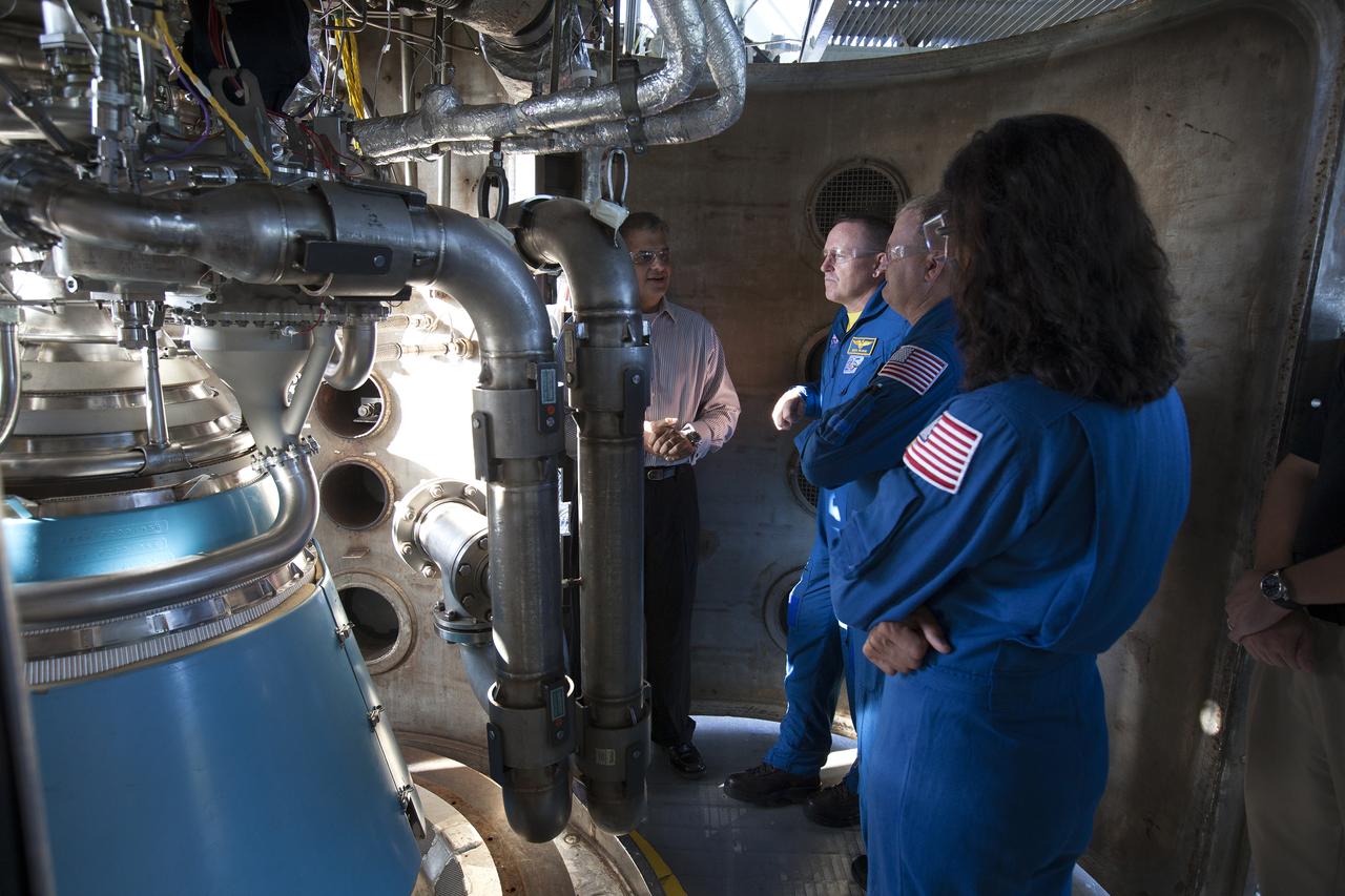 Carlos Rodriguez, from left, manager of systems development, verification and testing for Aerojet Rocketdyne, talks with NASA astronauts Barry "Butch" Wilmore, Eric Boe and Suni Williams as the group surveys an RL10 engine as it stands in a vacuum chamber at Aerojet Rocketdyne's test stand in West Palm Beach, Florida. The engine will be one of two used for the Centaur upper stage during a United Launch Alliance Atlas V mission to launch Boeing's CST-100 Starliner on a flight test carrying a crew. The engine was test-fired as part of acceptance testing to confirm the engine is ready for flight. 