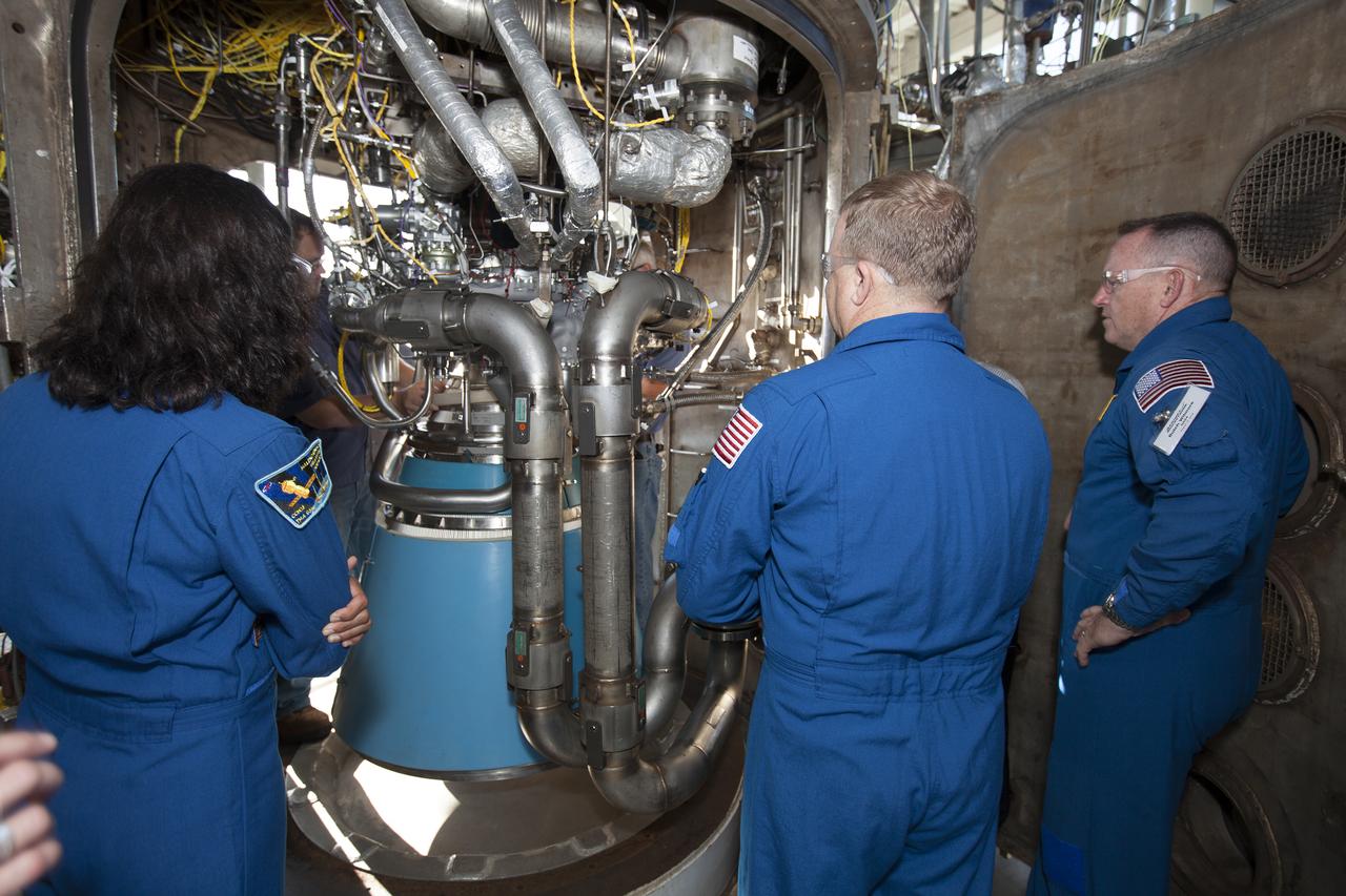 NASA astronauts Suni Williams, from left, Eric Boe and Barry "Butch" Wilmore survey an RL10 engine as it stands in a vacuum chamber at Aerojet Rocketdyne's test stand in West Palm Beach, Florida. The engine will be one of two used for the Centaur upper stage during a United Launch Alliance Atlas V mission to launch Boeing's CST-100 Starliner on a flight test carrying a crew. The engine was test-fired as part of acceptance testing to confirm the engine is ready for flight. 