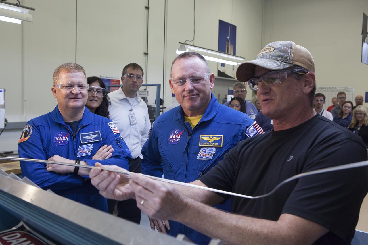 NASA astronauts Eric Boe, from left, and Barry "Butch" Wilmore listen as an Aerojet Rocketdyne engineer discusses aspects of an RL10 engine during a tour of Aerojet Rocketdyne's facility in West Palm Beach, Florida. The engine will be one of two used for the Centaur upper stage during a United Launch Alliance Atlas V mission to launch Boeing's CST-100 Starliner on a flight test carrying a crew. The engine was test-fired as part of acceptance testing to confirm the engine is ready for flight. 