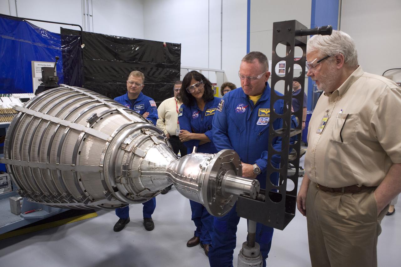 NASA astronauts Eric Boe, from left, Barry "Butch" Wilmore and Suni Williams listen as United Launch Alliance engineer Tom Harper discusses aspects of an RL10 engine during a tour of Aerojet Rocketdyne's facility in West Palm Beach, Florida. The engine will be one of two used for the Centaur upper stage during a United Launch Alliance Atlas V mission to launch Boeing's CST-100 Starliner on a flight test carrying a crew. The engine was test-fired as part of acceptance testing to confirm the engine is ready for flight.