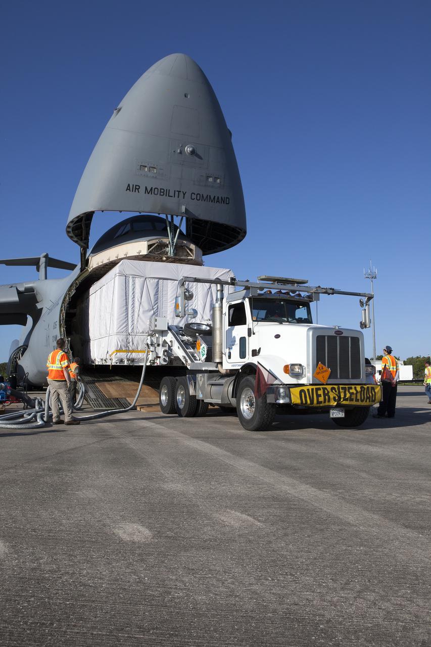 A truck with a specialized transporter drives out of the cargo hold of an Air Force C-5 Galaxy transport plane at the Shuttle Landing Facility at NASA's Kennedy Space Center in Florida to deliver the GOES-R spacecraft for launch processing. The GOES series are weather satellites operated by NOAA to enhance forecasts. The spacecraft is to launch aboard a United Launch Alliance Atlas V rocket in November.