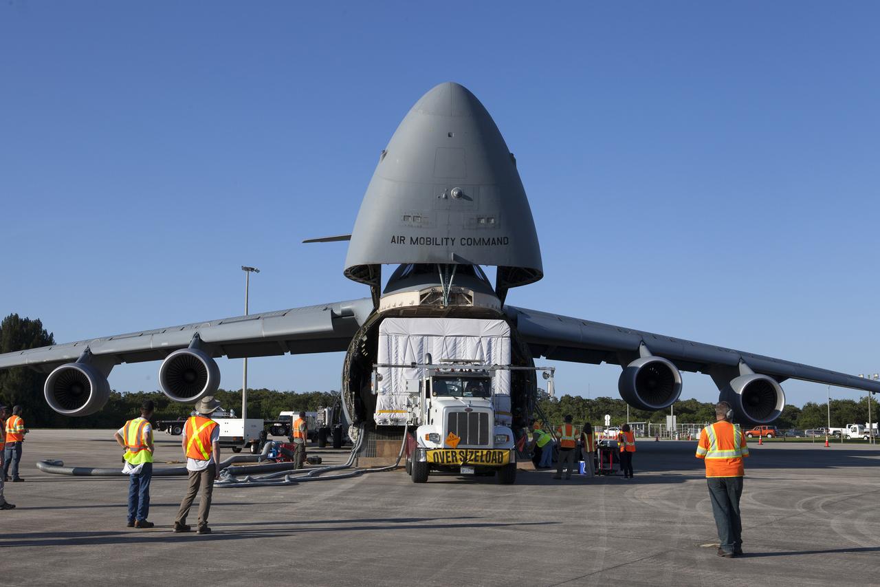 A truck with a specialized transporter drives out of the cargo hold of an Air Force C-5 Galaxy transport plane at the Shuttle Landing Facility at NASA's Kennedy Space Center in Florida to deliver the GOES-R spacecraft for launch processing. The GOES series are weather satellites operated by NOAA to enhance forecasts. The spacecraft is to launch aboard a United Launch Alliance Atlas V rocket in November.