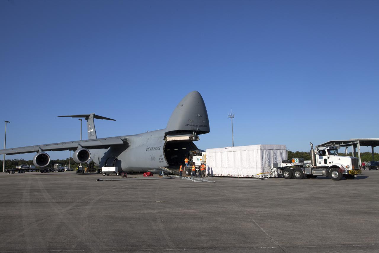 A truck with a specialized transporter drives out of the cargo hold of an Air Force C-5 Galaxy transport plane at the Shuttle Landing Facility at NASA's Kennedy Space Center in Florida to deliver the GOES-R spacecraft for launch processing. The GOES series are weather satellites operated by NOAA to enhance forecasts. The spacecraft is to launch aboard a United Launch Alliance Atlas V rocket in November.