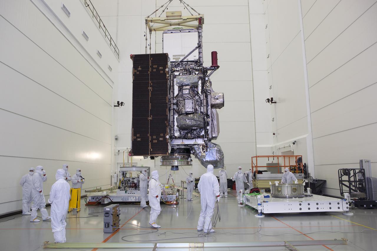 An overhead crane moves the GOES-R spacecraft toward its work stand inside the Astrotech payload processing facility in Titusville, Florida near NASA’s Kennedy Space Center. GOES-R will be the first satellite in a series of next-generation NOAA Geostationary Operational Environmental Satellites. The spacecraft is to launch aboard a United Launch Alliance Atlas V rocket in November.